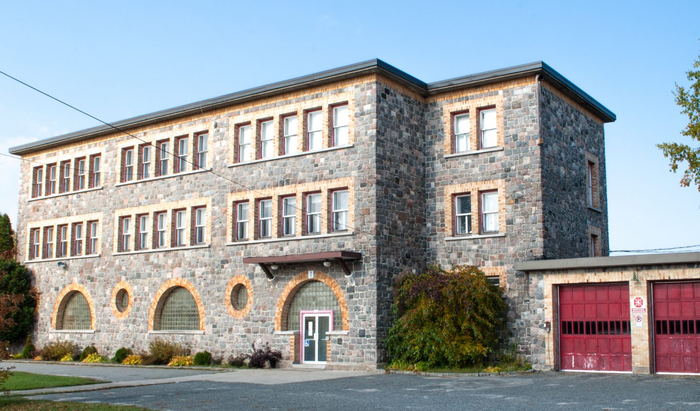 école datant de 1945 construite en pierre avec fenêtres rondes en demi-cercle situé au Témiscamingue à Laverlochère-Angliers, secteur Angliers